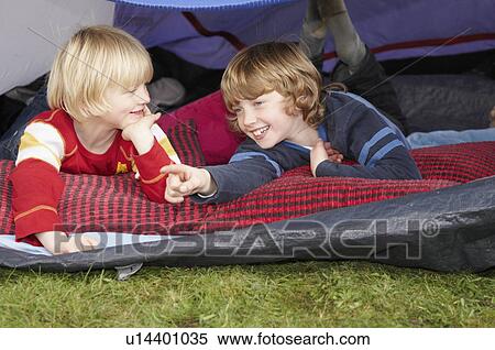 Stock Photography - Two boys looking out of tent. Fotosearch