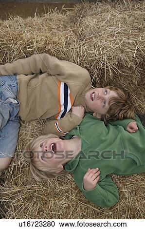 Stock Image - Two boys on hay bales. Fotosearch