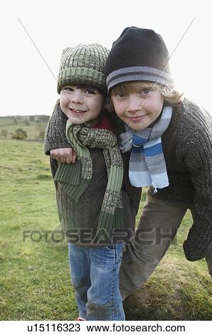 Stock Image - Two boys on hill in countryside. Fotosearch