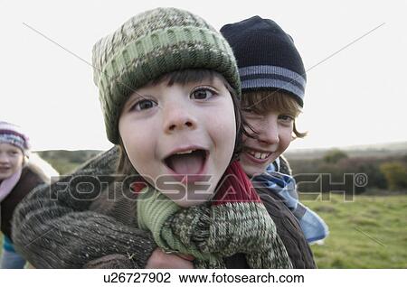 Two boys playing in field View Large Photo Image Stock Image - Two boys playing in field. Fotosearch
