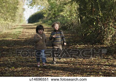 Stock Image - Two boys racing on country lane. Fotosearch