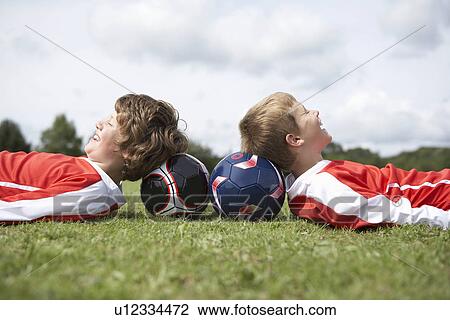 Two boys resting with heads on balls View Large Photo Image Stock Image - Two boys resting with heads on balls. Fotosearch