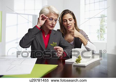 Stock Photography - Two female architects at work in office. Fotosearch
