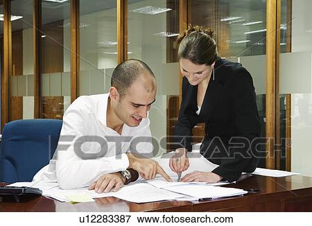 Stock Photo - Two young adults working together. Fotosearch