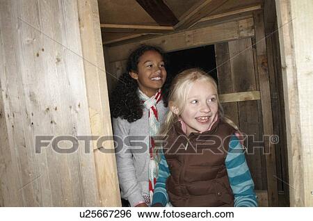 Two young girls enter treehouse View Large Photo Image Stock Photograph - Two young girls enter treehouse. Fotosearch