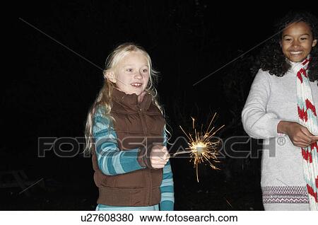 Two young girls with sparklers View Large Photo Image Stock Image - Two young girls with sparklers. Fotosearch