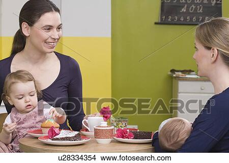 Picture - Two young mothers with their babies. Fotosearch