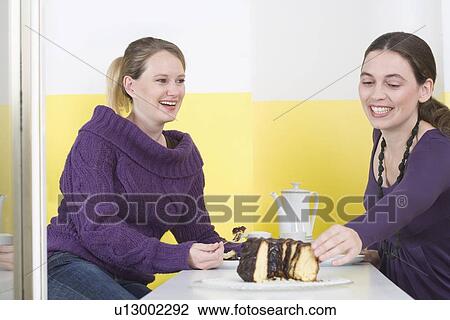 "Two young women, eating cake" View Large Photo Image Stock Image - "Two young women, eating cake". Fotosearch
