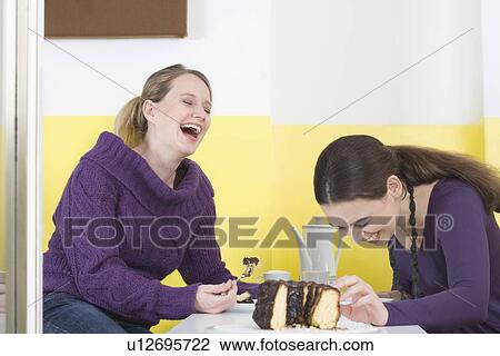 "Two young women on table, laughing" View Large Photo Image Stock Image - "Two young women on table, laughing". Fotosearch