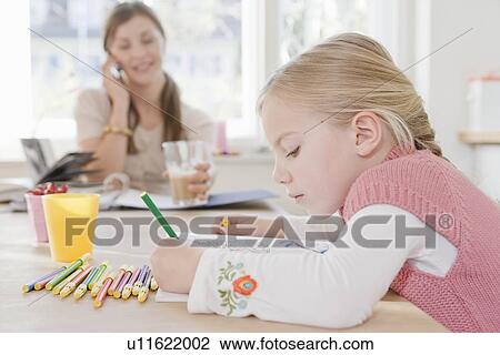 Woman and girl sitting at table writing View Large Photo Image Stock Image - Woman and girl sitting at table writing. Fotosearch