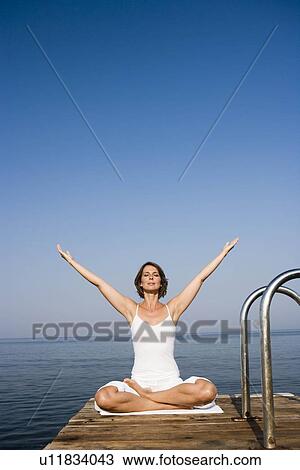 Woman doing yoga on a pier View Large Photo Image Stock Image - Woman doing yoga on a pier. Fotosearch