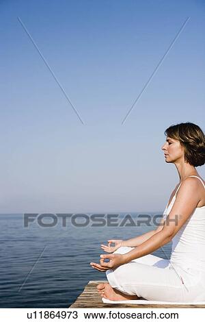 Woman doing yoga on a pier View Large Photo Image Stock Image - Woman doing yoga on a pier. Fotosearch