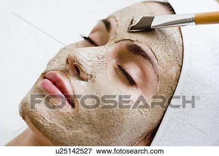 Stock Photo - Woman getting face mask. Fotosearch