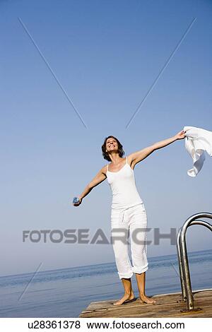 Stock Photo - Woman having fun on a pier. Fotosearch