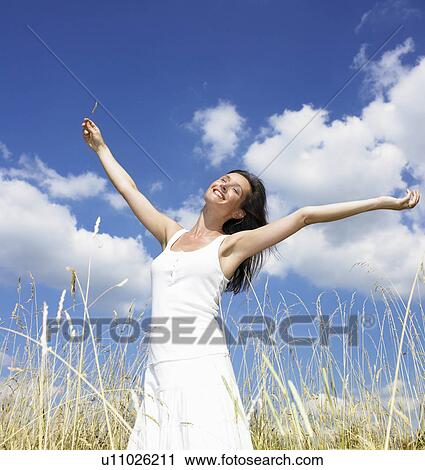 "Woman in a field, enjoying the sun" View Large Photo Image Stock Image - "Woman in a field, enjoying the sun". Fotosearch