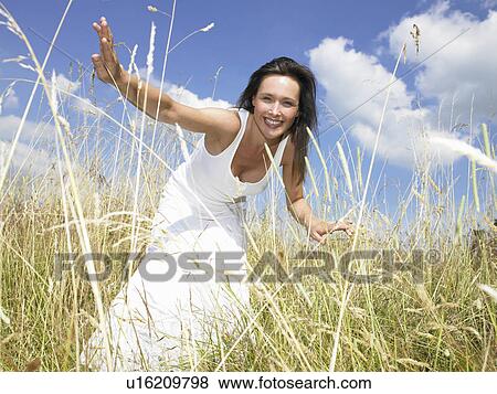 "Woman in a field, looking at camera" View Large Photo Image Stock Photo - "Woman in a field, looking at camera". Fotosearch