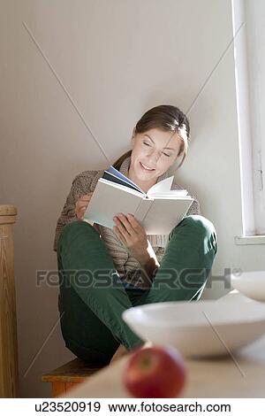 Stock Photo - Woman in kitchen reading. Fotosearch