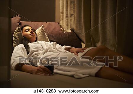 Stock Photo - Woman in robe laying on cushions. Fotosearch