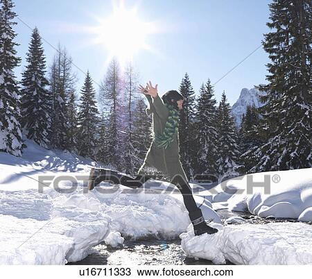 Woman jumping across stream View Large Photo Image Stock Image - Woman jumping across stream. Fotosearch