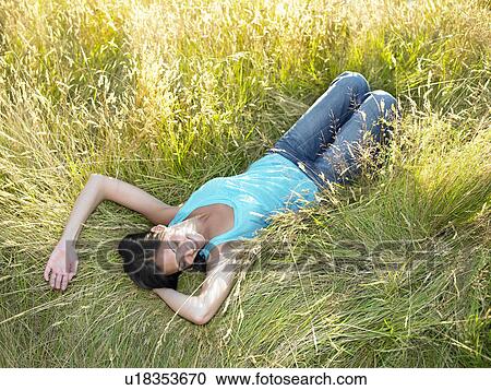 Woman laying down in a field View Large Photo Image Stock Image - Woman laying down in a field. Fotosearch