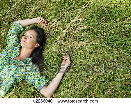 Woman laying down in a field View Large Photo Image Stock Image - Woman laying down in a field. Fotosearch