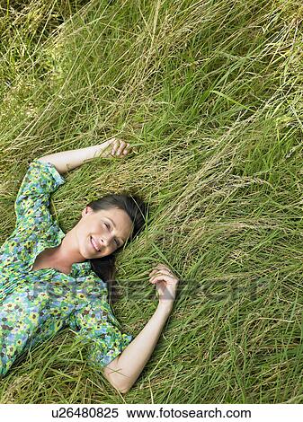 Stock Photography - Woman laying down in a field. Fotosearch