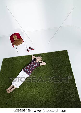 Picture - Woman laying down on grass. Fotosearch