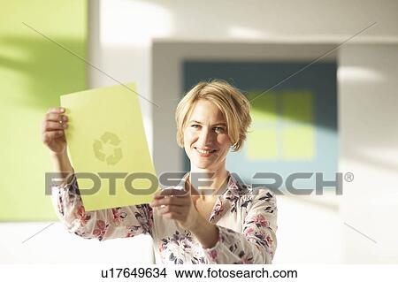Woman looking at green sheet with logo View Large Photo Image Picture - Woman looking at green sheet with logo. Fotosearch