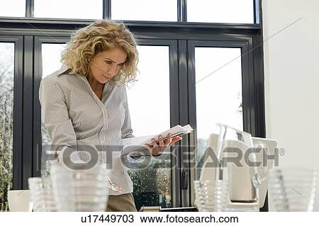 Stock Image - Woman looking at papers and computer. Fotosearch