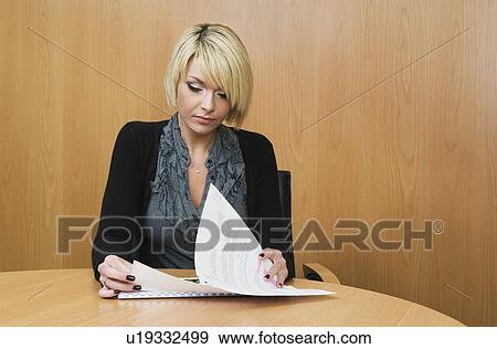 Woman looking at papers in boardroom View Large Photo Image Stock Photo - Woman looking at papers in boardroom. Fotosearch