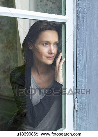 Woman looking through window View Large Photo Image Stock Photography - Woman looking through window. Fotosearch