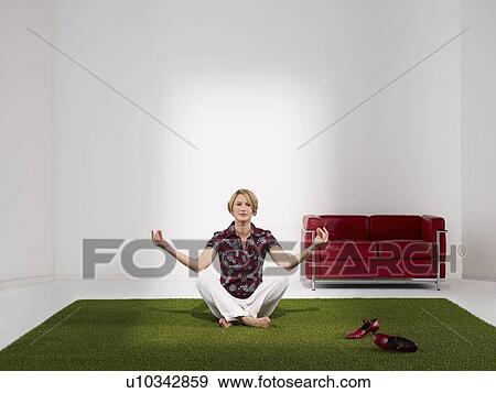 Woman meditating in green office View Large Photo Image Stock Photo - Woman meditating in green office. Fotosearch