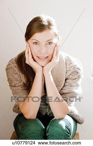 Woman on chair smiling at viewer View Large Photo Image Picture - Woman on chair smiling at viewer. Fotosearch