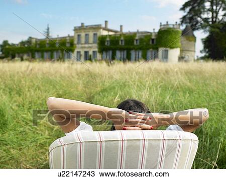 "Woman on sofa in a field, castle view" View Large Photo Image Stock Image - "Woman on sofa in a field, castle view". Fotosearch