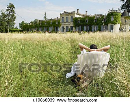 "Woman on sofa in a field, castle view" View Large Photo Image Stock Photo - "Woman on sofa in a field, castle view". Fotosearch