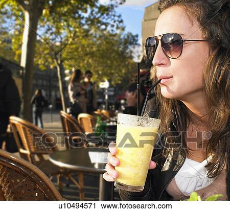 Stock Image - Woman on terrace of café. Fotosearch