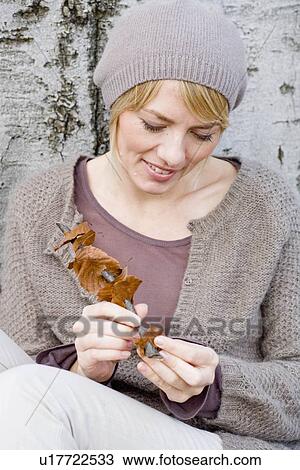Stock Image - Woman playing with a fallen leave. Fotosearch