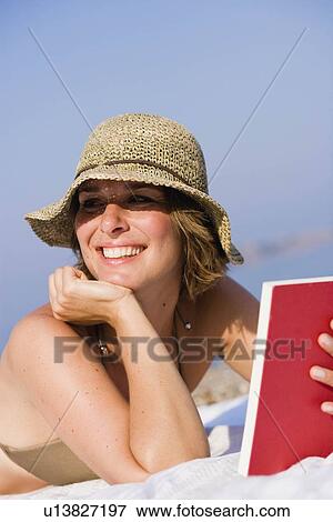 Stock Photo - Woman reading a book on the beach. Fotosearch
