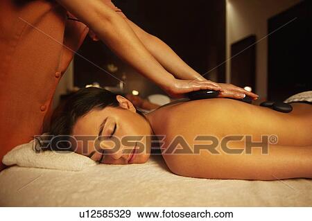 Stock Photo - Woman receiving hot stone massage. Fotosearch