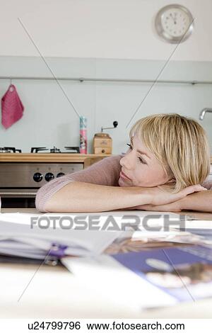 Woman resting head on kitchen table View Large Photo Image Stock Photograph - Woman resting head on kitchen table. Fotosearch
