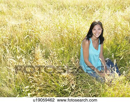 Woman seated in a field View Large Photo Image Stock Image - Woman seated in a field. Fotosearch