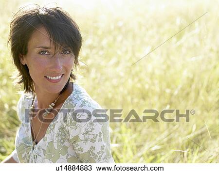 Woman sitting in a field View Large Photo Image Stock Image - Woman sitting in a field. Fotosearch