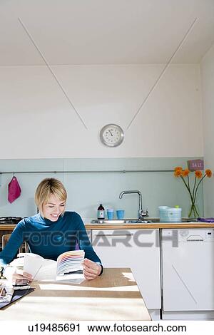 Woman sitting in kitchen View Large Photo Image Stock Image - Woman sitting in kitchen. Fotosearch