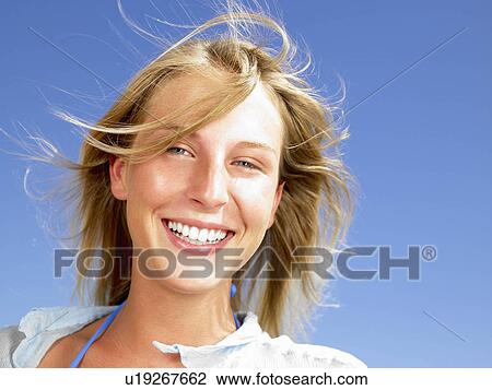Stock Image - "Woman smiling, blue sky above". Fotosearch