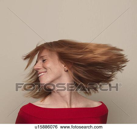 Stock Photograph - "Woman spinning head around, hair flying". Fotosearch