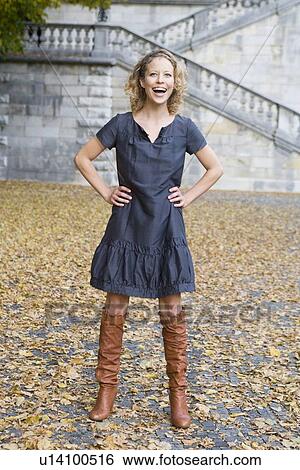 Stock Photograph - Woman standing in park laughing. Fotosearch