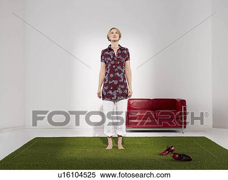 Stock Photography - Woman standing on grass in green office. Fotosearch