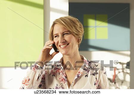 Woman using mobile phone in green loft View Large Photo Image Picture - Woman using mobile phone in green loft. Fotosearch