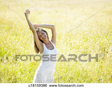 "Woman walking in a field, smiling" View Large Photo Image Stock Photograph - "Woman walking in a field, smiling". Fotosearch