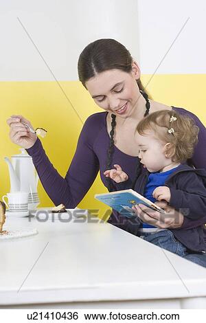 "Woman with daughter on lap, eating cake" View Large Photo Image Stock Photograph - "Woman with daughter on lap, eating cake". Fotosearch